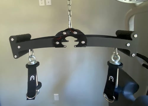 Buyer photo of the Back Bar hanging from a cable machine with strap handles attached