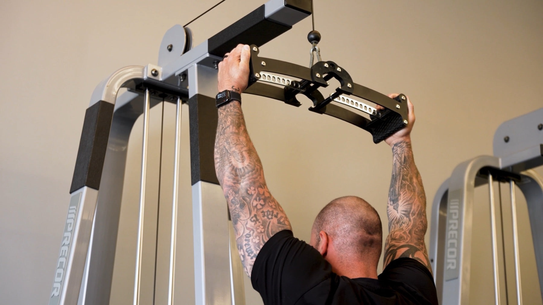 Lifter pulling the Back Bar down from a cable station with a neutral palm-facing grip