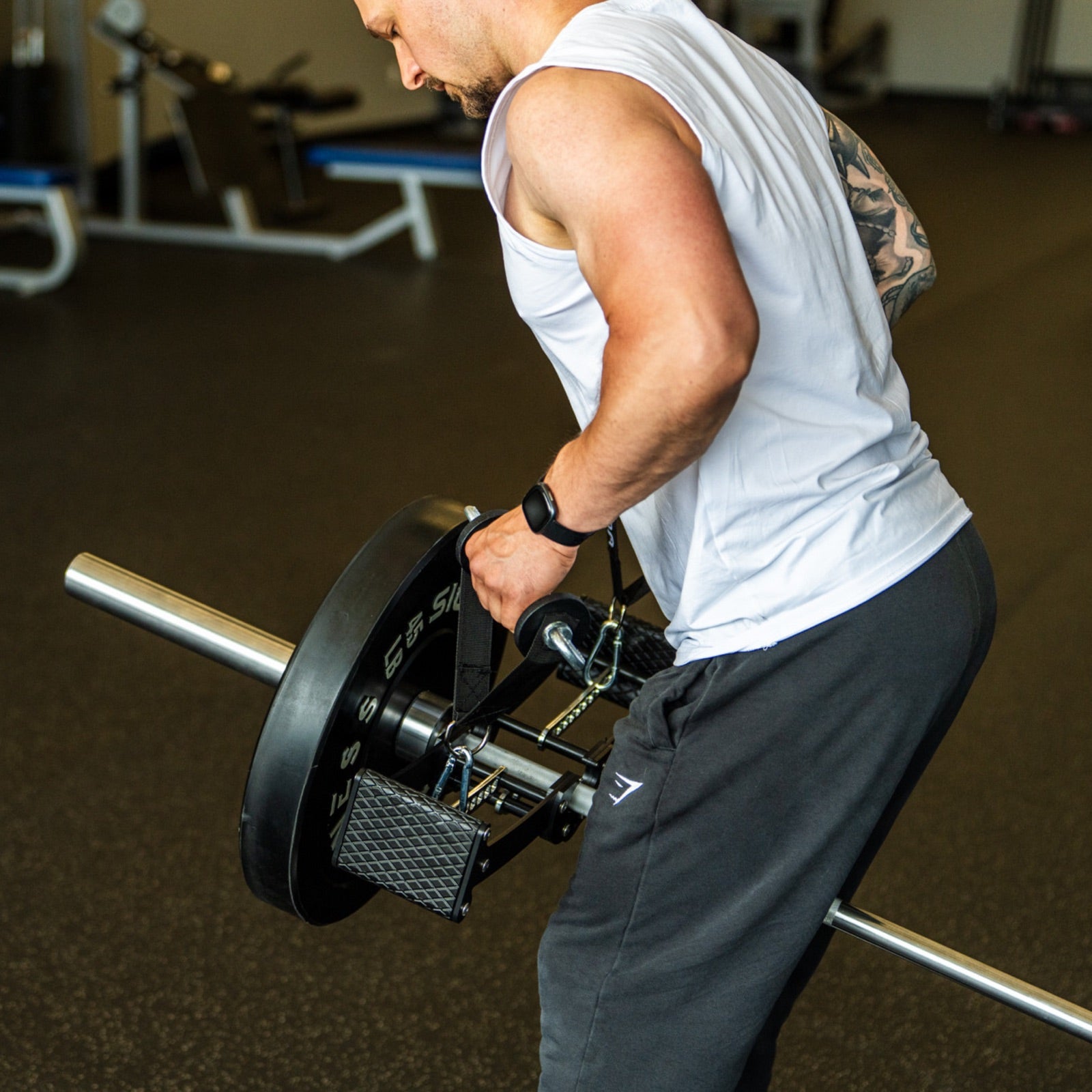 Lifter mid-pull on a bent-over bilateral landmine row with the Back Bar seated over a loaded sleeve